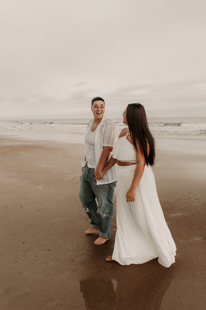 Couple enjoying a laugh after their fall elopement at the beach