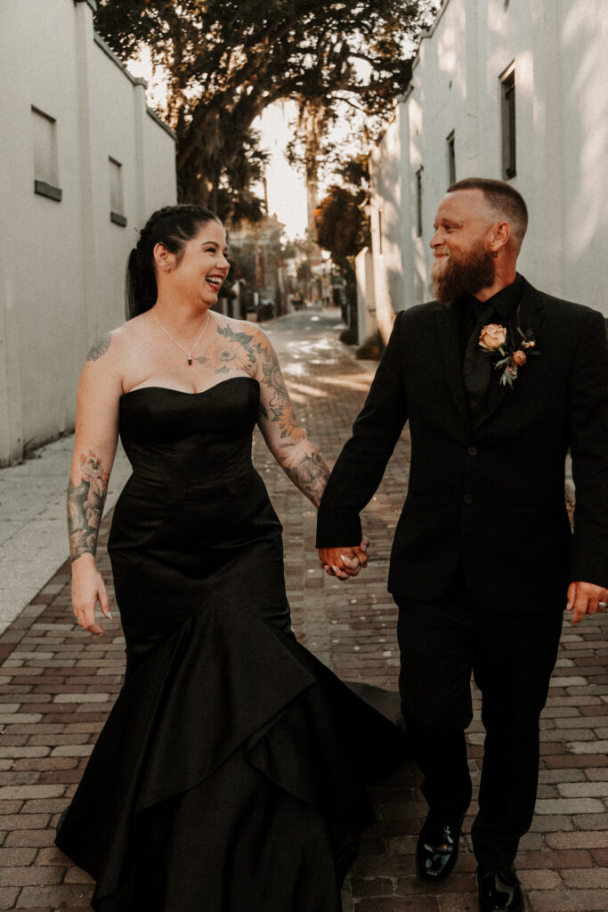 Couple walking down cobble stone street dressed in all black for their Florida Elopement