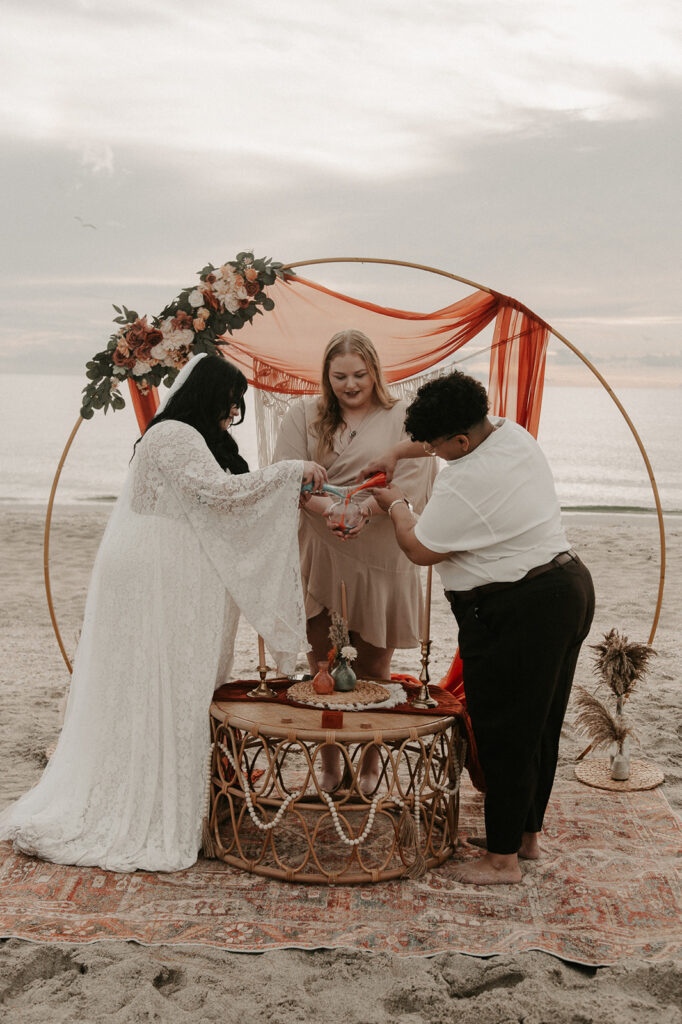 Leah and Olivia's sand ceremony during their beach elopement ceremony in sarasota florida