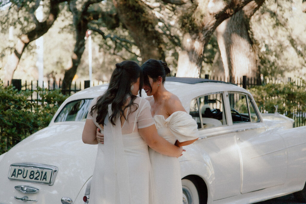 LGBTQ couple after a first look on their elopement day in front of an old Rolls Royce during their fall elopement