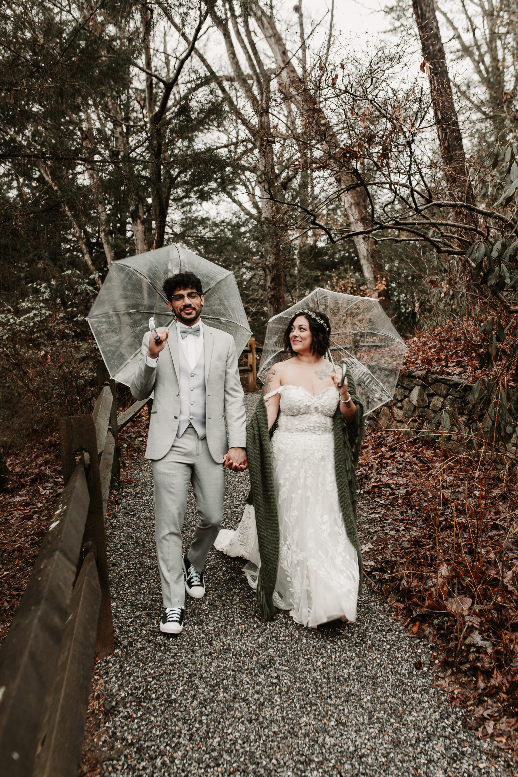 Bride and Groom walking in the rain at the Asheville Botanical gardens for their elopement in North Carolina