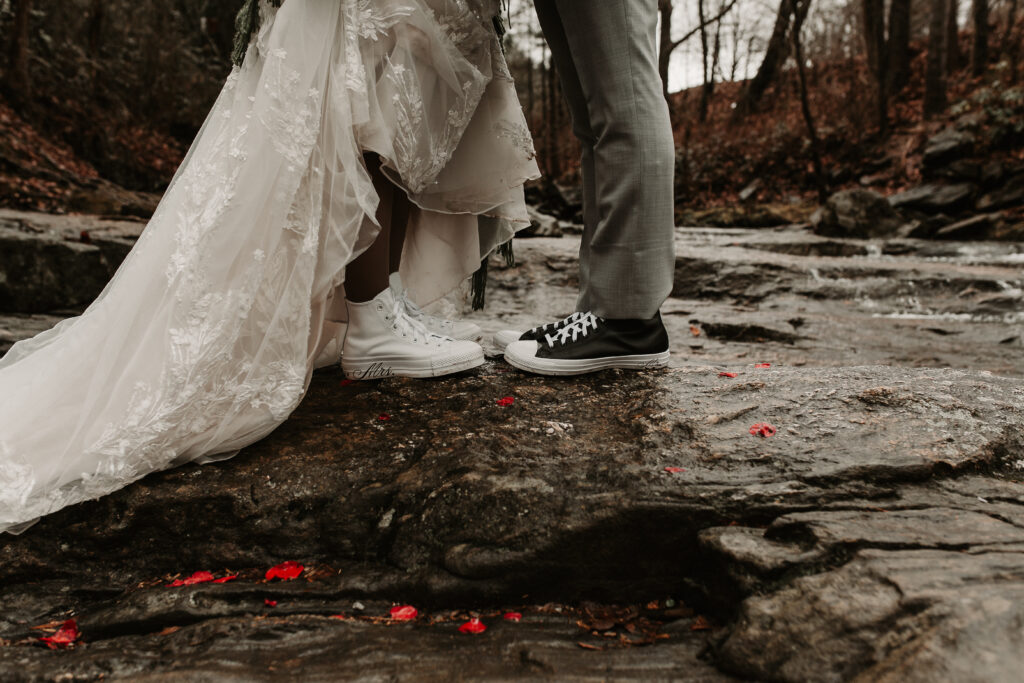 Edgy bride and groom converse surrounded by rose petals 