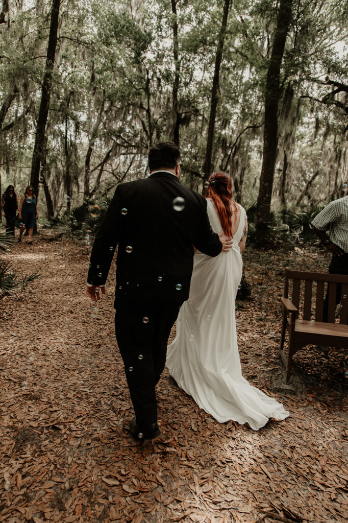 bride and groom walking away from their guests after their elopement ceremony