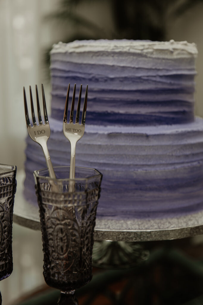 purple wedding cake with the toasting glasses and cake forks