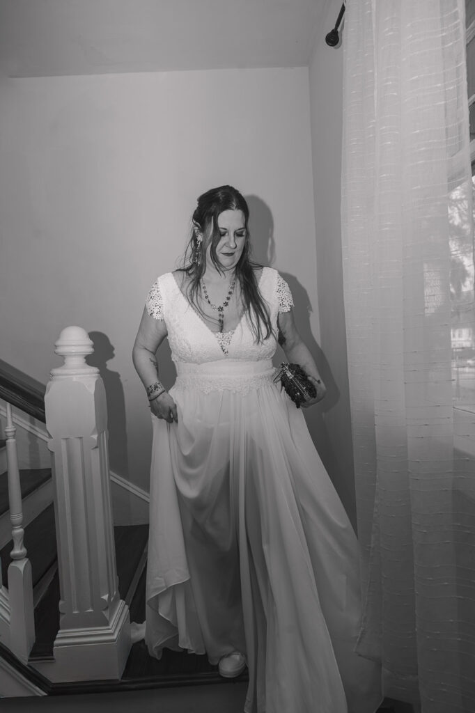 black and white on bride walking down the stairs on her elopement day