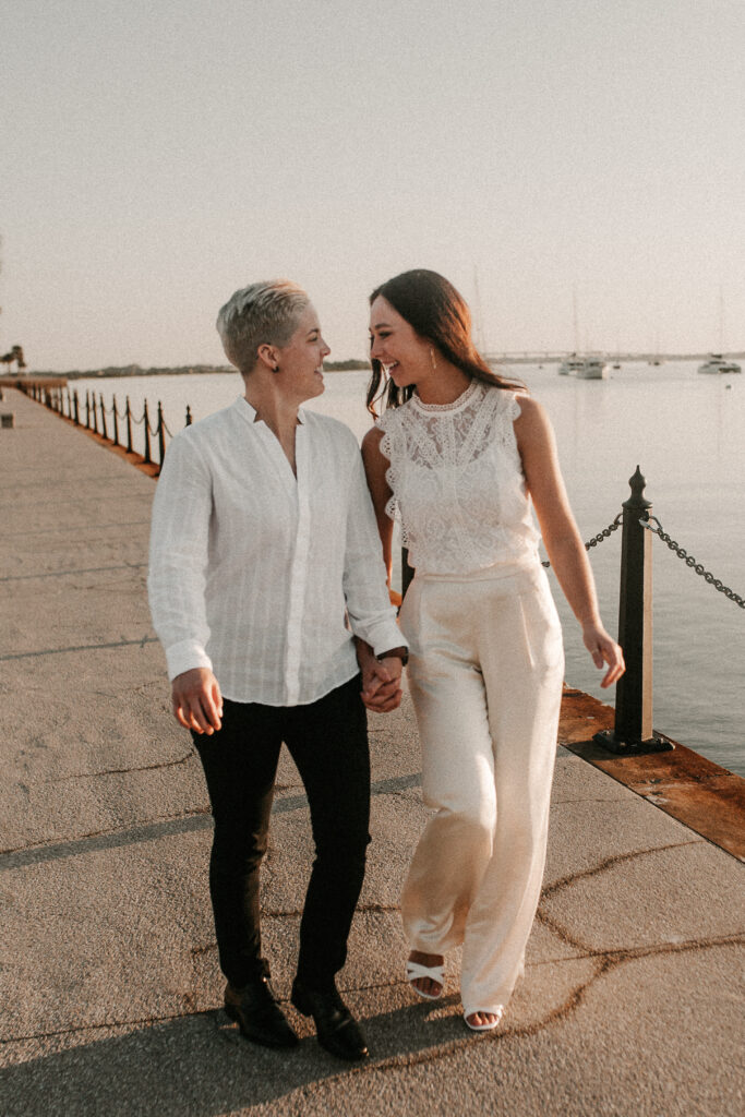 Ashley and Emily walking down the riverwalk in St. Augustine in wedding attire