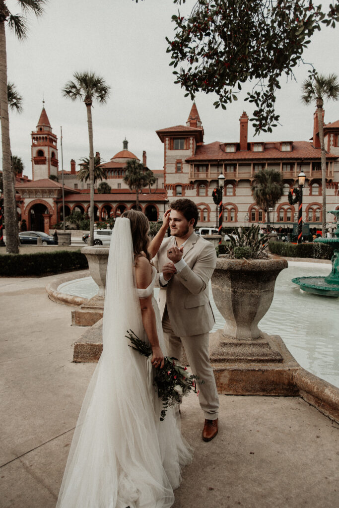 bride is fixing grooms hair as he fixes his jacket