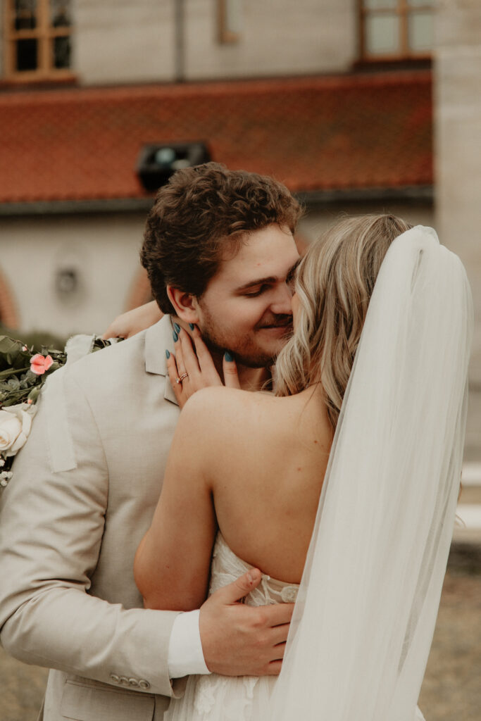 Groom is about to kiss the bride. The brides hand is on the grooms face