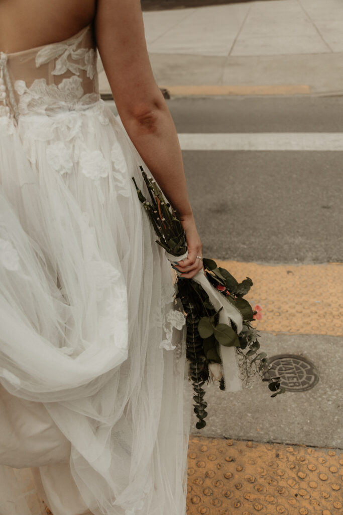 Bride carrying her flowers across the street