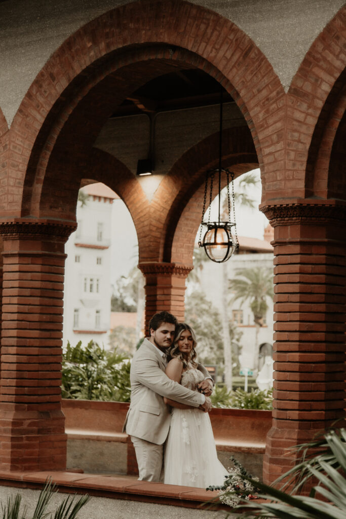 Groom hugging bride from behind