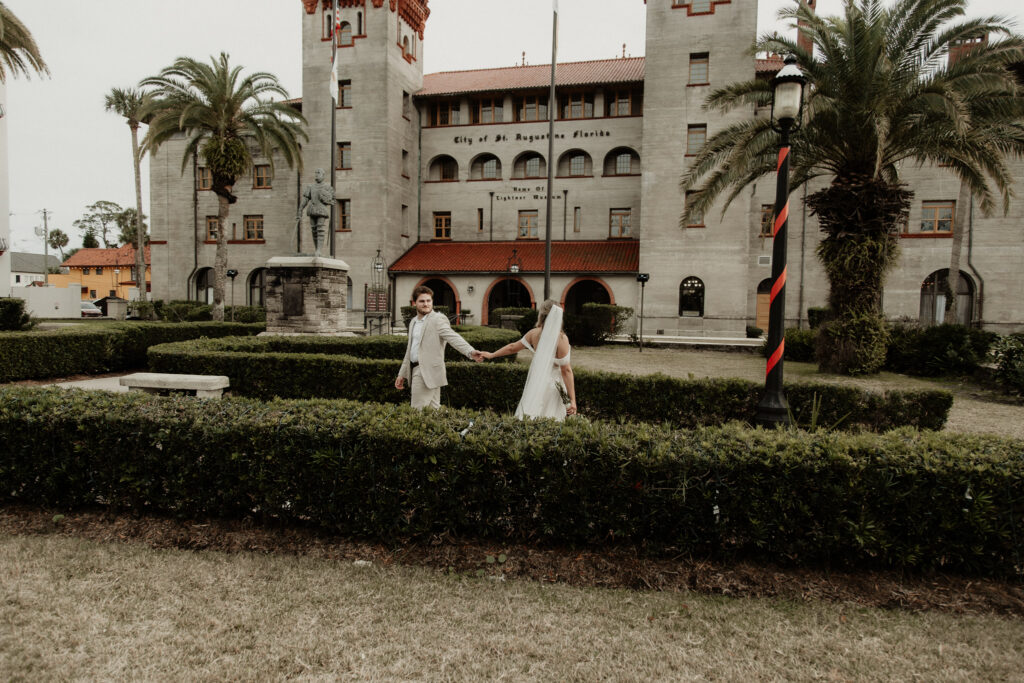 bride and groom walk past each other looking back at each other grabbing hands.