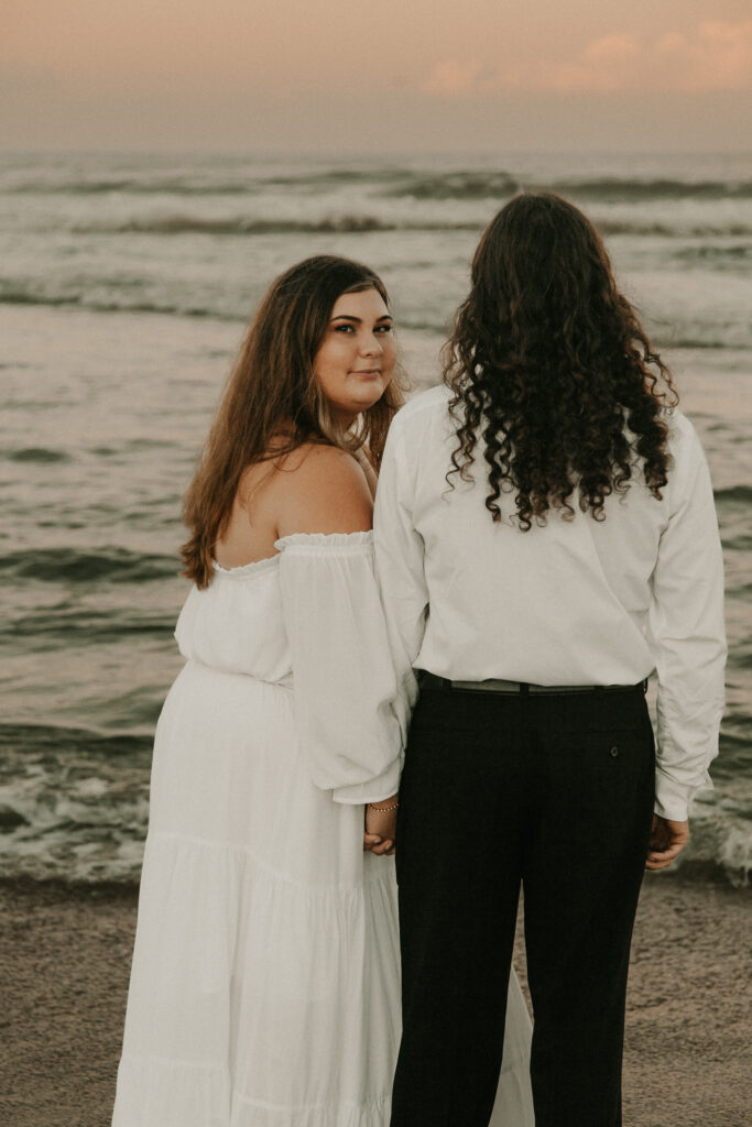 Bride looking over grooms shoulder at Vilano beach with cotton candy skys