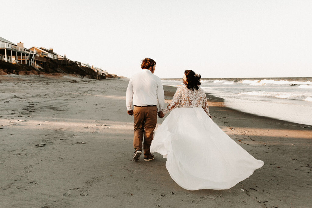 Bride and groom walking away from their friends and family during the florida beach elopement