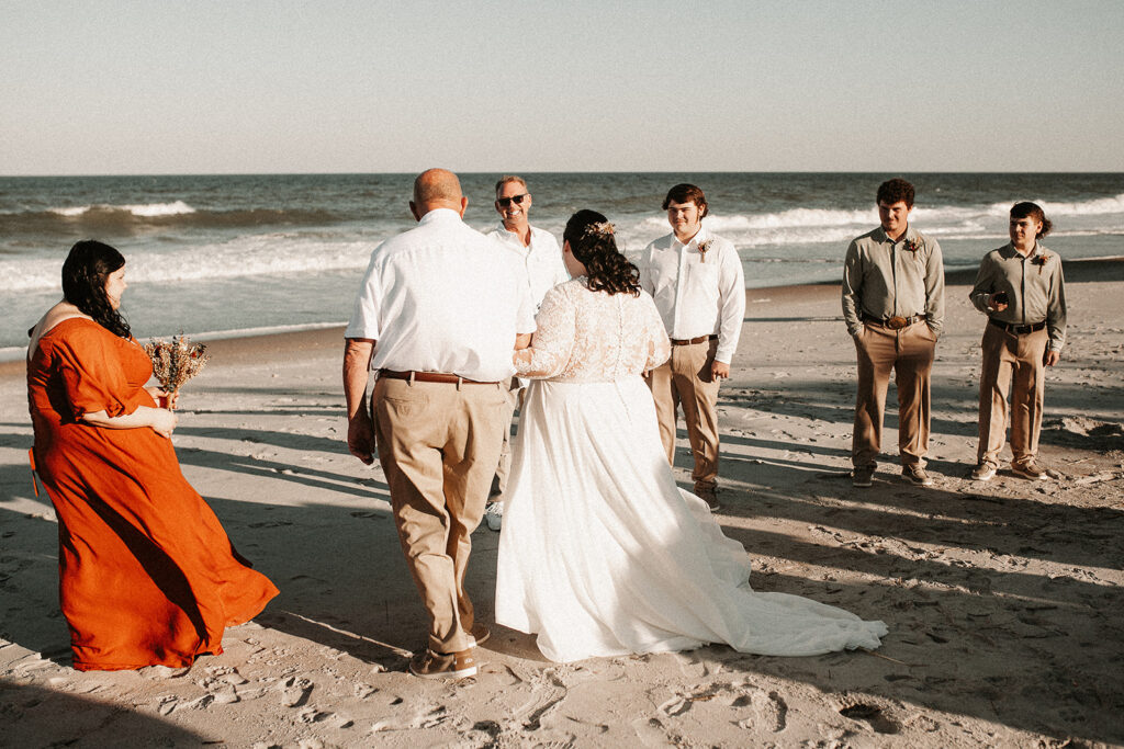 Grandfather walking bride down to the groom on a florida beach